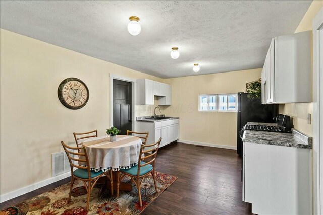8899 Walnut St, Lakeview, OH 43331 - dining space featuring sink, a textured ceiling, and dark hardwood / wood-style flooring