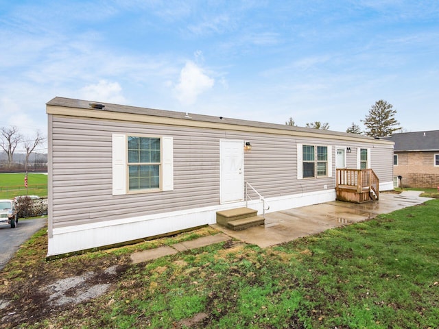 rear view of house featuring a lawn and a patio area