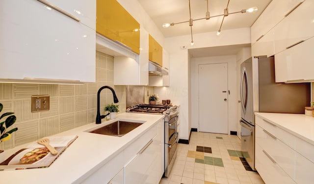 kitchen featuring stainless steel appliances, sink, white cabinets, and decorative backsplash