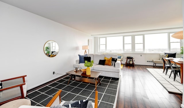 living room featuring dark wood-type flooring and a healthy amount of sunlight