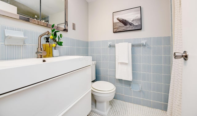 bathroom featuring tile patterned floors, toilet, tile walls, and vanity