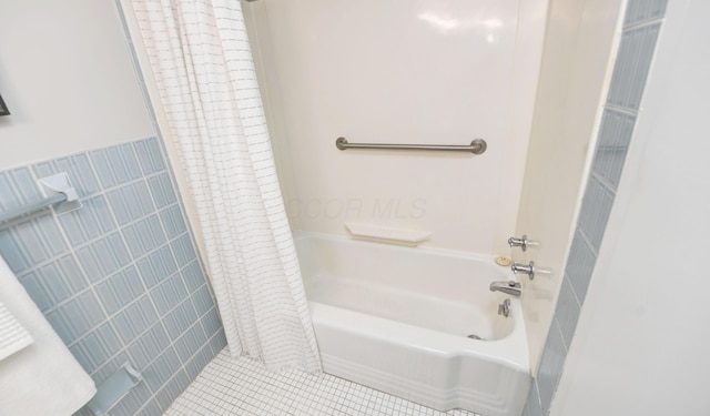 bathroom with tile walls, shower / tub combo, and tile patterned floors