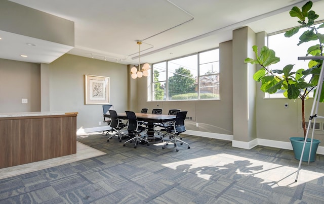 dining space featuring track lighting, a chandelier, and carpet flooring