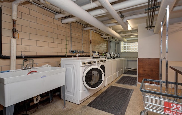 clothes washing area with washer and dryer and sink