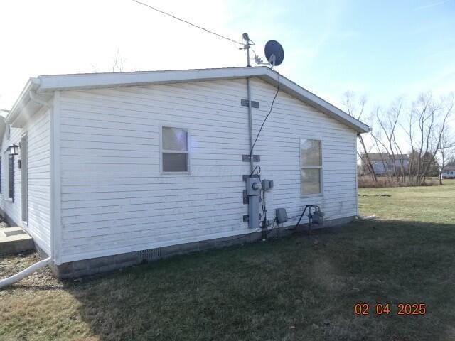 view of side of home with a yard