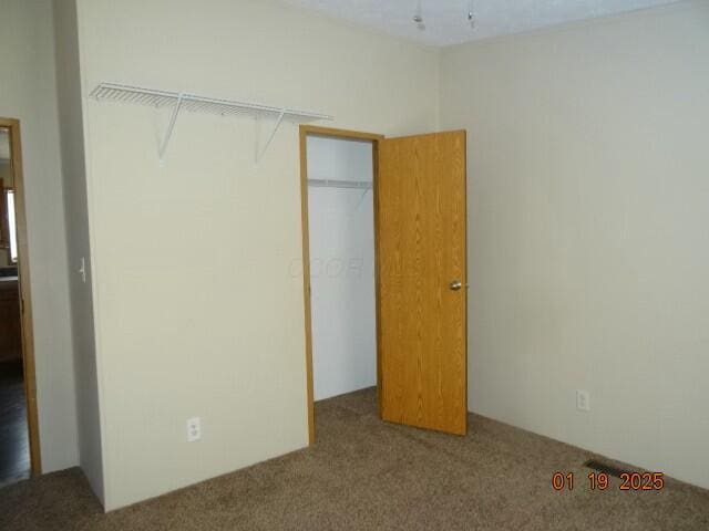 unfurnished bedroom with a closet and carpet