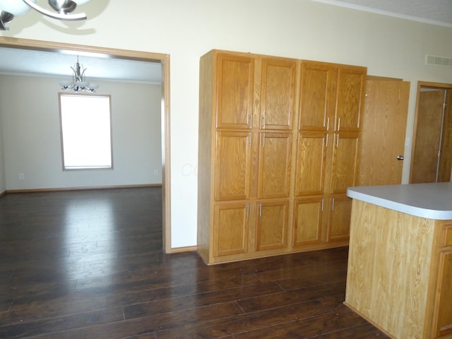 kitchen with ornamental molding, an inviting chandelier, and dark hardwood / wood-style flooring