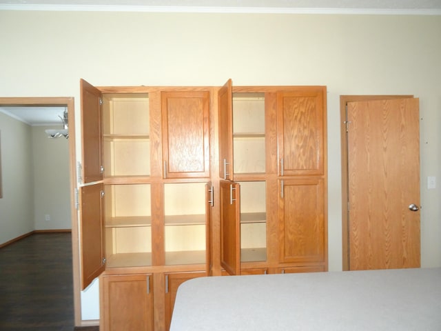 bedroom with crown molding and dark wood-type flooring