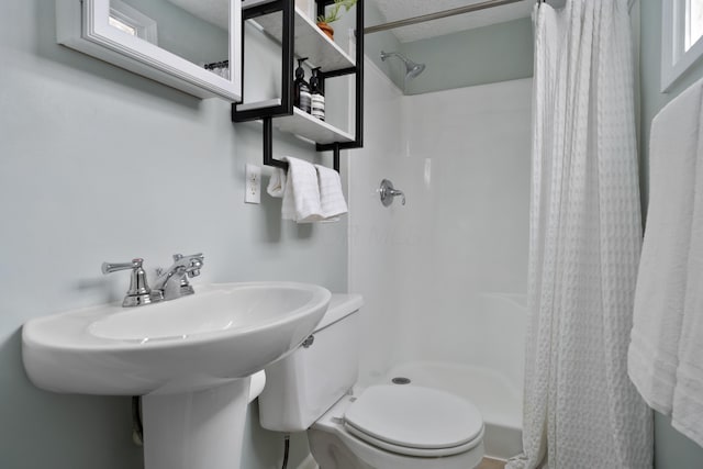 bathroom featuring toilet and walk in shower