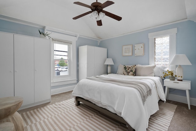 bedroom with light carpet, two closets, lofted ceiling, and ceiling fan