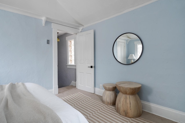 bedroom featuring ornamental molding, lofted ceiling, and light carpet