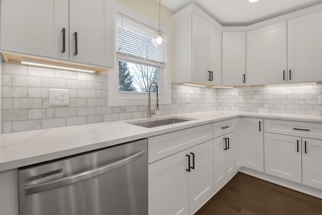 kitchen featuring sink, dishwasher, white cabinetry, light stone counters, and decorative light fixtures