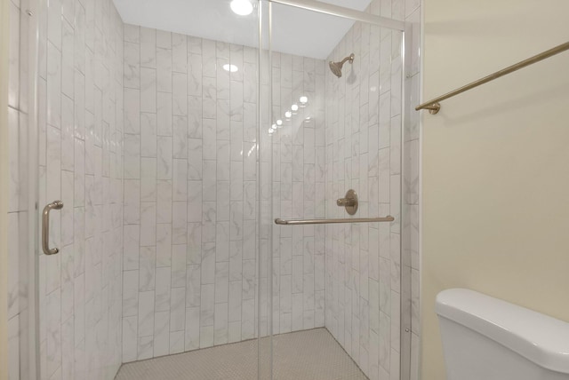 bathroom featuring toilet and an enclosed shower