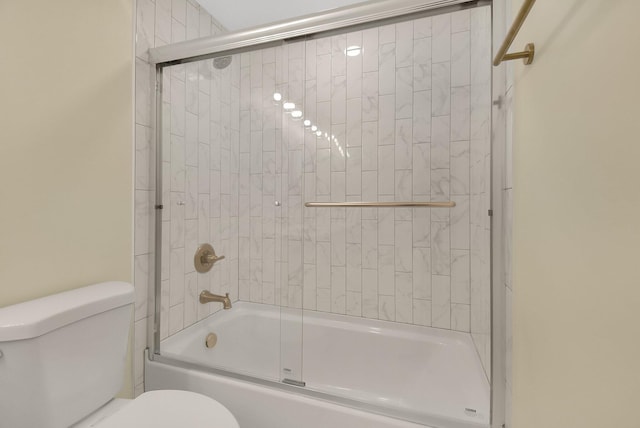 bathroom with shower / bath combination with glass door and toilet