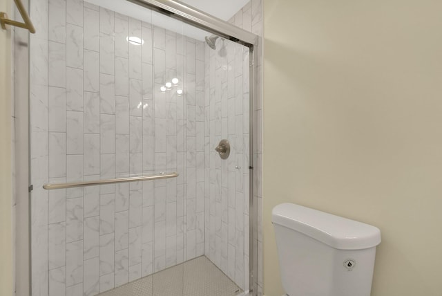 bathroom featuring walk in shower and toilet