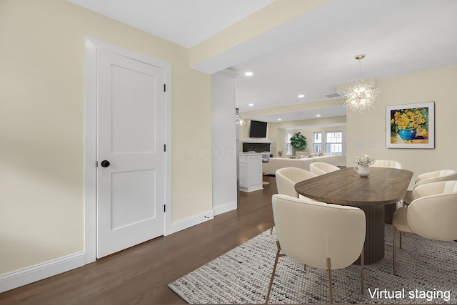 dining area with an inviting chandelier and dark hardwood / wood-style flooring