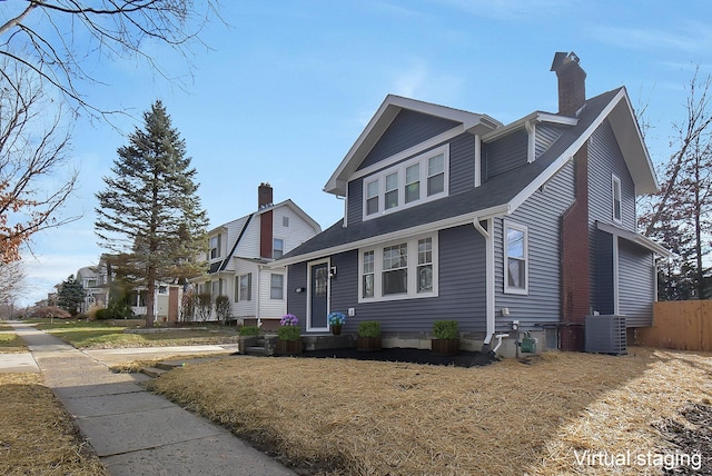 view of front facade with central AC unit and a front yard