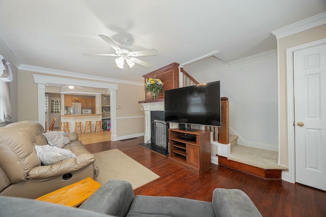 living room with ornate columns, crown molding, and dark hardwood / wood-style flooring