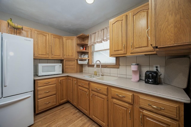 kitchen with lofted ceiling, sink, decorative backsplash, white appliances, and light hardwood / wood-style flooring