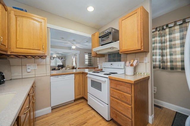 kitchen featuring ceiling fan, light hardwood / wood-style floors, white appliances, and decorative backsplash