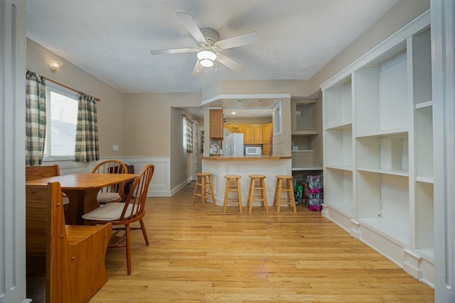 dining room with ceiling fan and light hardwood / wood-style floors