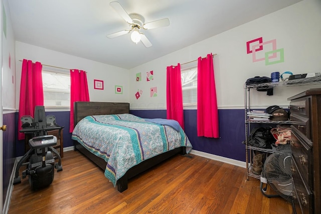 bedroom with multiple windows, dark hardwood / wood-style floors, and ceiling fan