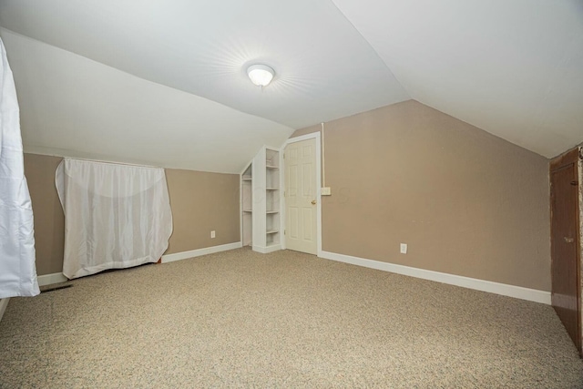 additional living space with lofted ceiling and carpet flooring