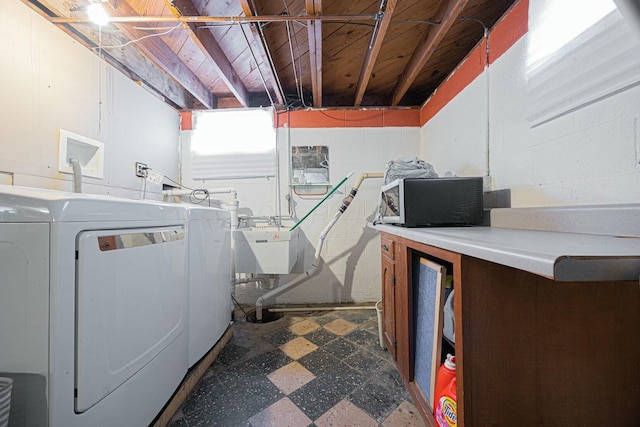 clothes washing area featuring sink and washer and clothes dryer