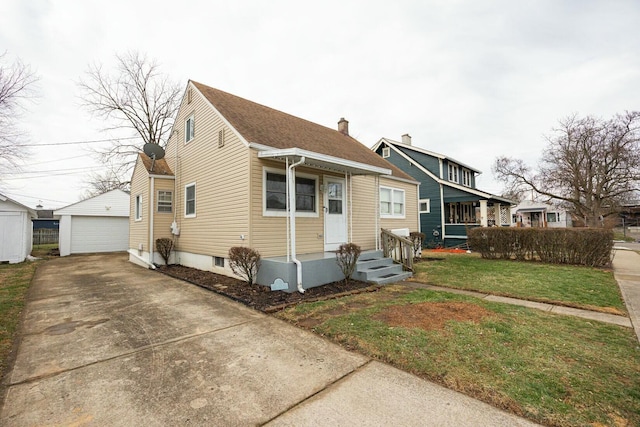 bungalow featuring an outbuilding, a garage, and a front yard