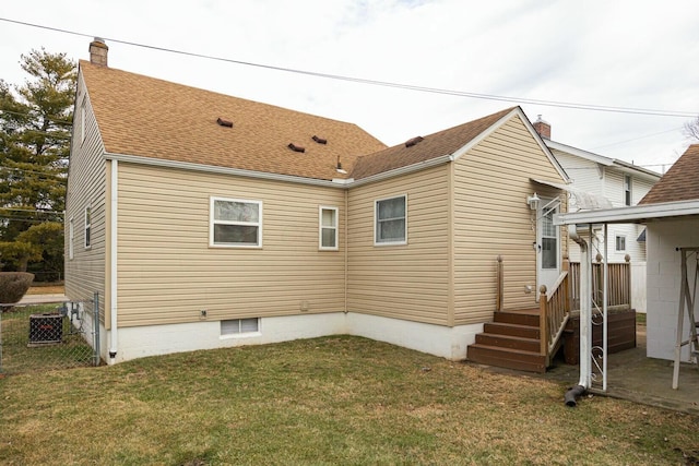 rear view of property featuring a lawn