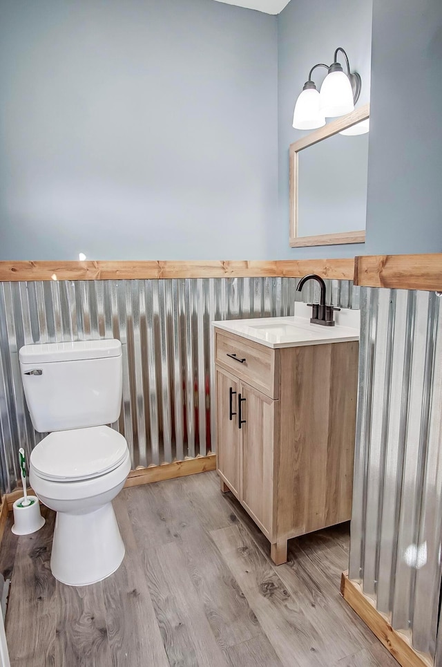 bathroom featuring hardwood / wood-style flooring, vanity, and toilet