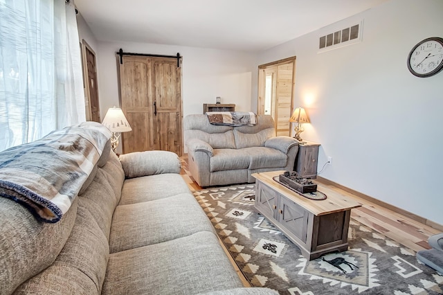 living room with wood-type flooring and a barn door