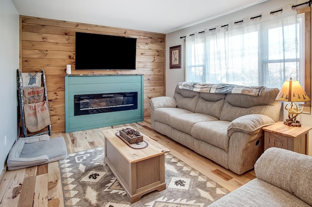 living room with light hardwood / wood-style flooring and wooden walls