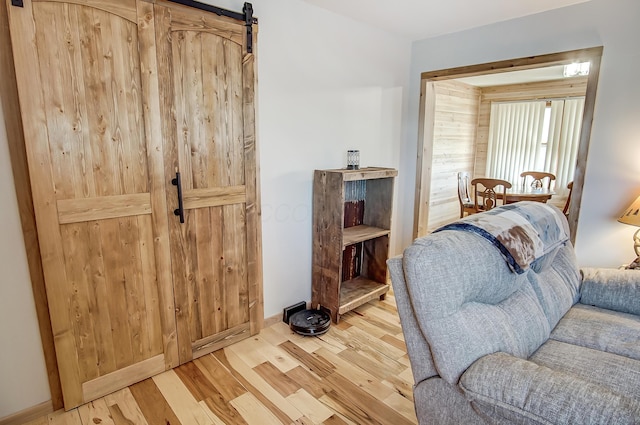 sitting room with a barn door and hardwood / wood-style floors