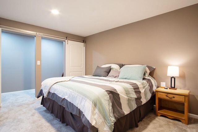 carpeted bedroom with a barn door