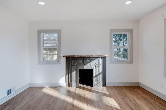 unfurnished living room with a fireplace and light hardwood / wood-style floors