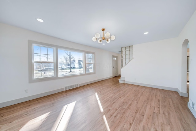 unfurnished living room featuring light hardwood / wood-style floors and a chandelier