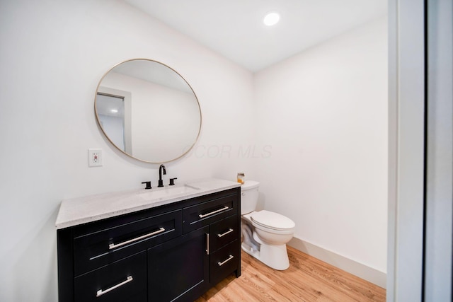 bathroom featuring vanity, wood-type flooring, and toilet