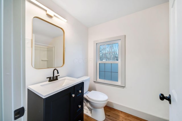 bathroom featuring vanity, wood-type flooring, and toilet