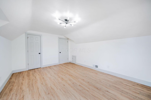 bonus room featuring lofted ceiling and light hardwood / wood-style floors