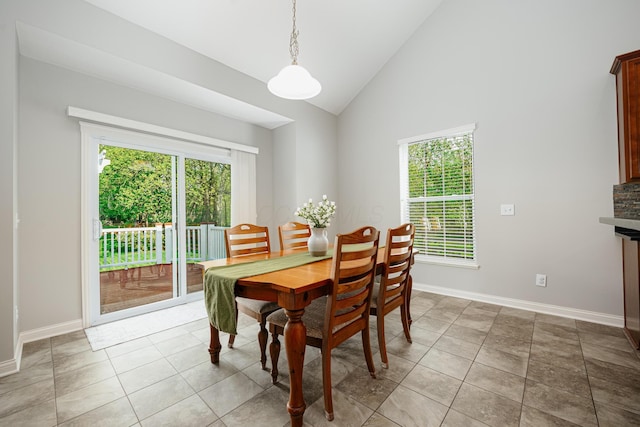 tiled dining room with high vaulted ceiling