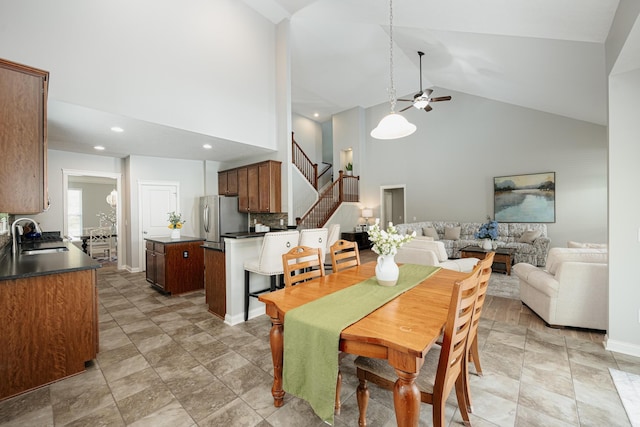 dining area with sink, high vaulted ceiling, and ceiling fan