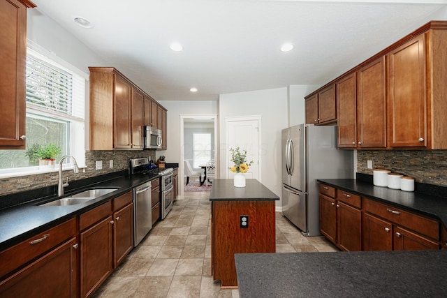 kitchen with stainless steel appliances, sink, a kitchen island, and a wealth of natural light