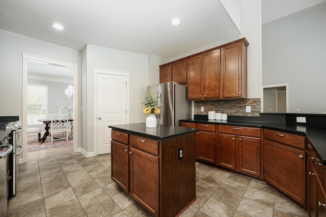 kitchen with dark stone countertops, backsplash, stainless steel fridge, and a kitchen island