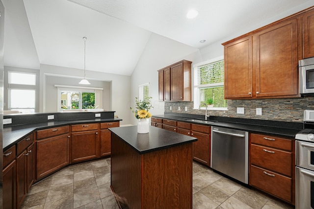 kitchen featuring lofted ceiling, sink, appliances with stainless steel finishes, tasteful backsplash, and a kitchen island