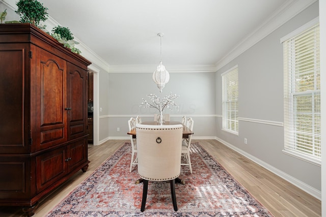 dining area featuring crown molding and light wood-type flooring