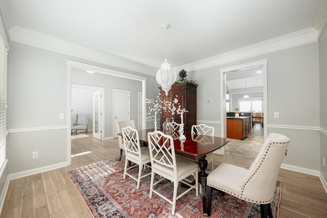 dining room with ornamental molding and light wood-type flooring