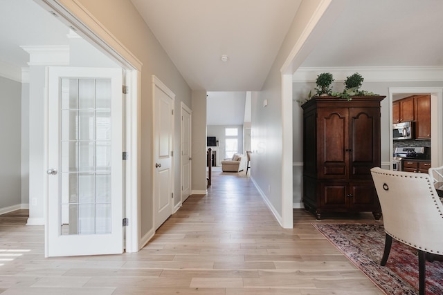 hall featuring crown molding and light hardwood / wood-style floors