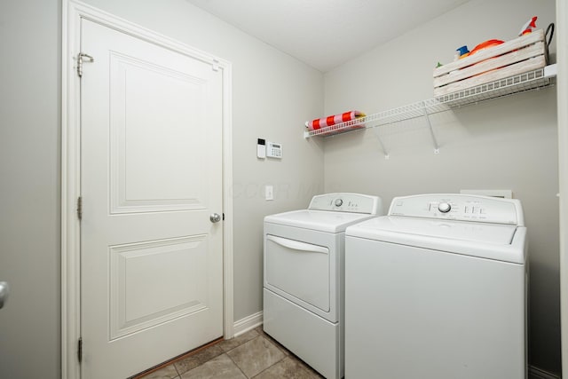 laundry room with washer and dryer and light tile patterned floors