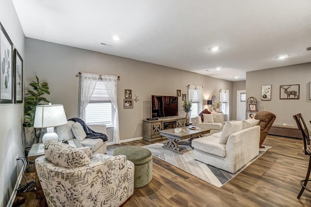 living room with dark hardwood / wood-style flooring and a wealth of natural light